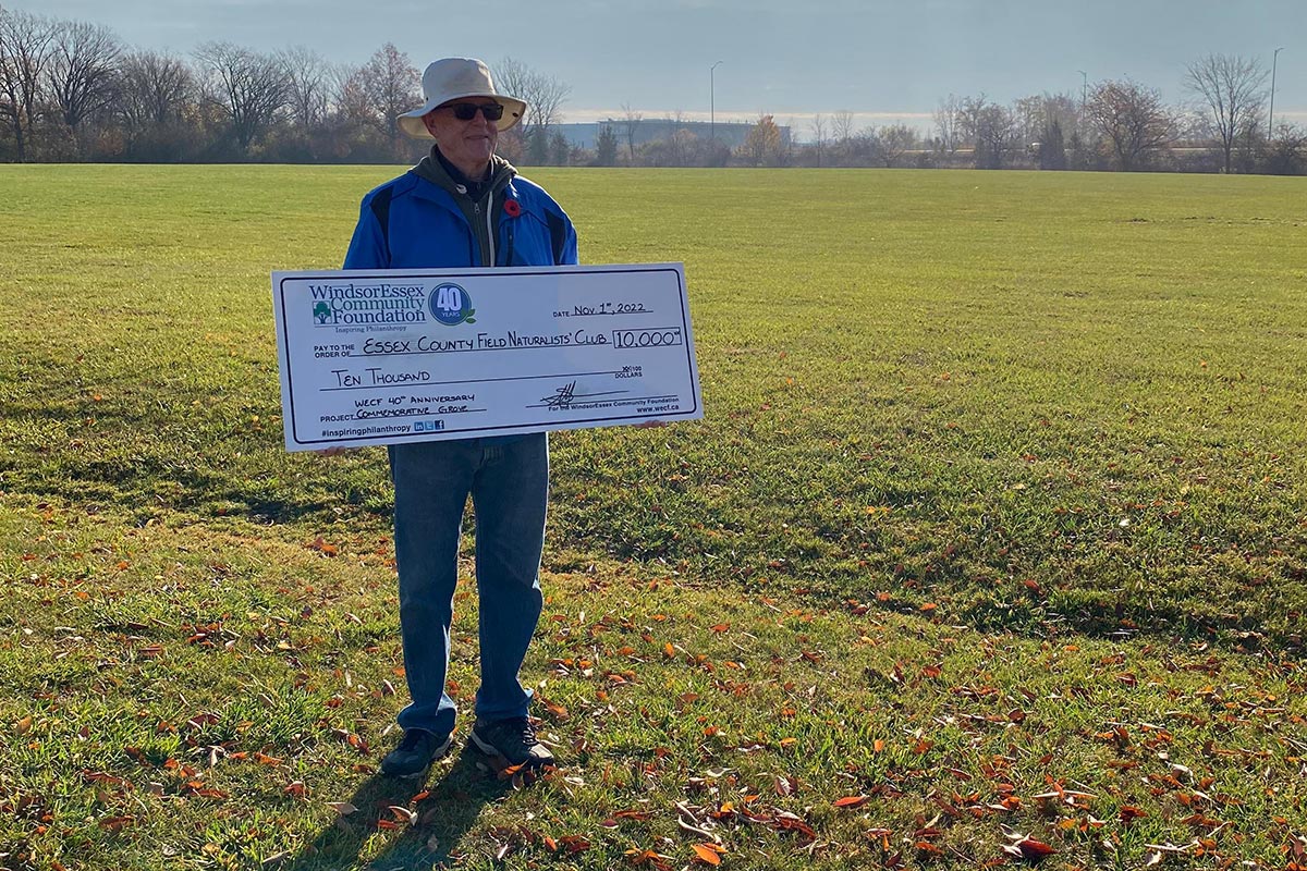 Older man holding donation check